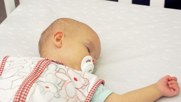 baby w dummy in cot